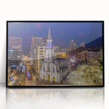 Large abstract wall art depicting a stylized Colombian landscape in muted earth tones, framed in black acrylic.