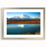 Textured art of abstract Alaskan scenery in muted gray and blue tones on a framed silver mat, ideal for bedroom ambiance.