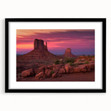 Abstract art print of Monument Valley in vibrant, colorful hues on a large textured canvas, framed in black.