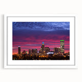 Abstract art print of Charlotte skyline in muted blue and gray tones on a framed white mat, ideal for dining room decor.