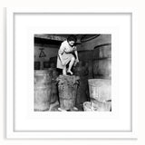 Abstract art print featuring silhouetted figures and food items in muted earth tones, framed in white.