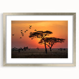 Textured art print depicting abstract African scenery in earth tones, framed in silver, ideal for bedroom art.