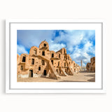 Abstract art print of a Tunisian landscape in muted earth tones on a framed white mat, ideal for dining room decor.