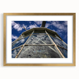 Textured abstract art print in vibrant blue and green shades, framed in gold, ideal for bedroom decor.