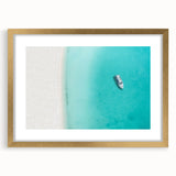 Abstract art print of Caribbean scenery in gold frame with mat, featuring serene blue and white tones.
