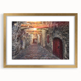 Abstract art print of a European scenery in muted gold and blue tones, framed with a gold mat.