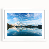 Abstract art print of the French Alps in muted blue and white tones, framed with a white mat, suitable for dining room decor.