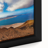 Close-up of textured black wall art featuring colorful, abstract scenery of the Canary Islands on a framed canvas.