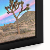 Close-up of a black wall art featuring a textured Joshua Tree scene in vibrant colors on a framed canvas.