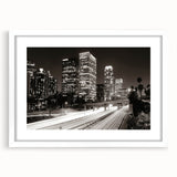 Abstract art print of Los Angeles skyline in muted gray and blue tones, framed with a white mat.