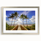 Textured art print of abstract Palm Beach scenery in muted blue and sand tones, framed in silver, ideal for bedroom decor.