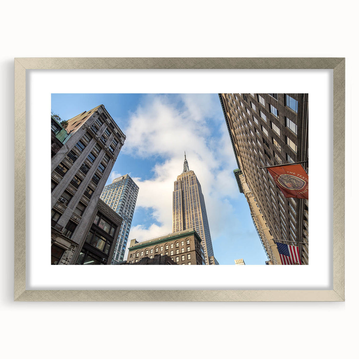 Textured abstract art print of NYC skyline in muted gray, displayed in a silver frame, suitable for bedroom decor.