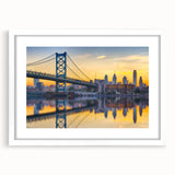 Abstract art print of Philadelphia skyline in muted blue and gray, framed in white, suitable for dining room decor.