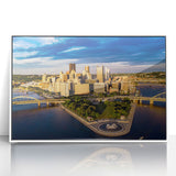 Art deco style poster of Pittsburgh skyline in muted gray and blue tones on a white framed acrylic.
