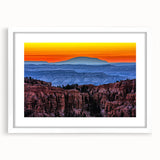 Abstract art print of Bryce Canyon in muted orange and red tones on a framed white mat, ideal for dining room decor.