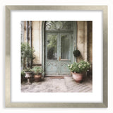Textured abstract art print featuring an intricate door design in muted earth tones, presented in a silver frame with mat.