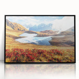 Large abstract wall art depicting a vibrant, geometric landscape in shades of orange and blue, framed in black acrylic.