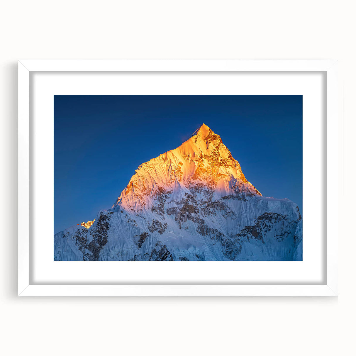 Abstract art print of Mount Everest in muted blue and white tones, framed with a white mat.