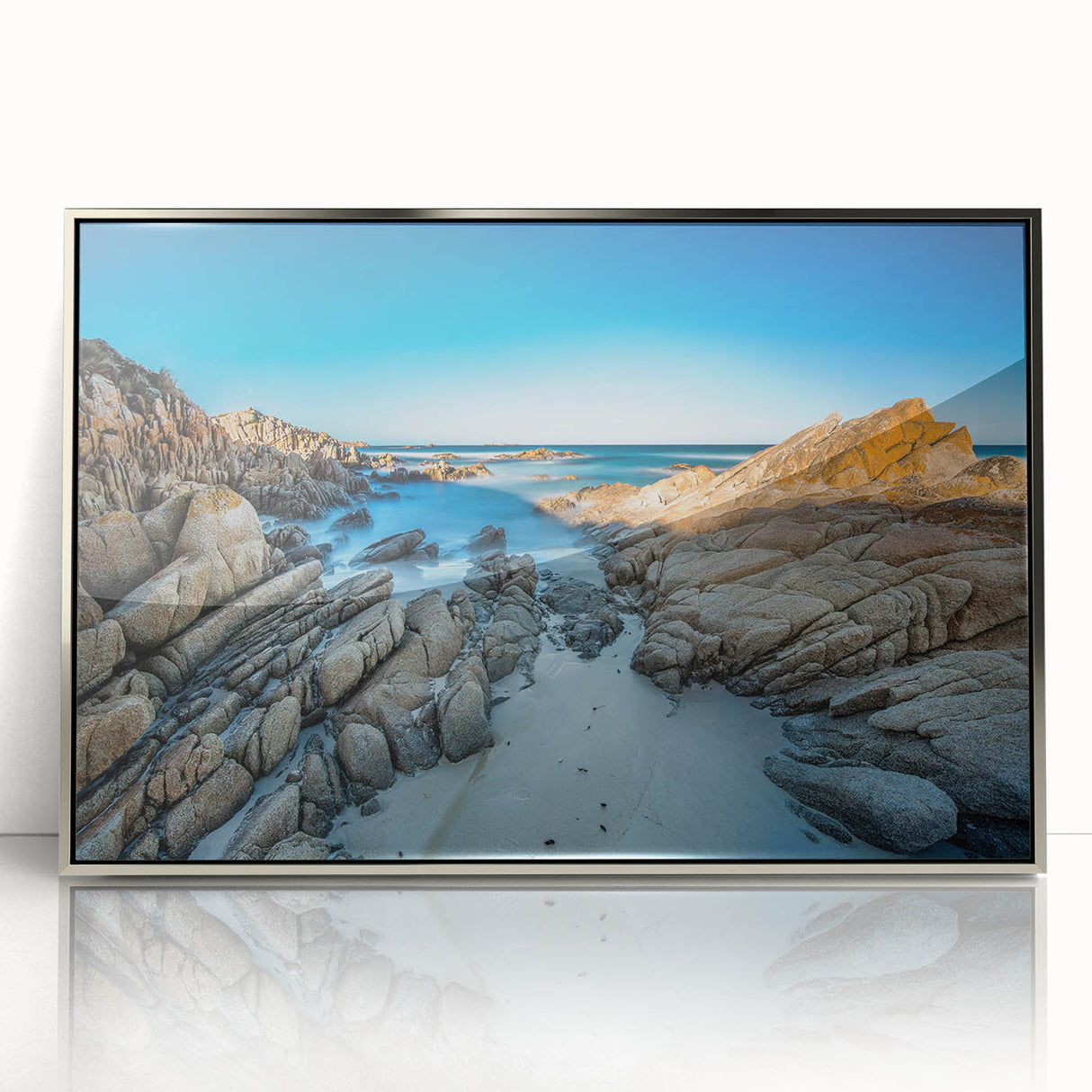 Art deco style poster of Tasmania scenery on silver-framed acrylic, featuring muted earth tones.