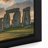 Close-up of a textured black wall art depicting Stonehenge in muted earthy tones on a framed canvas.