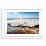 Abstract art print of the Dead Sea in muted blues and grays, framed in white, ideal for dining room decor.