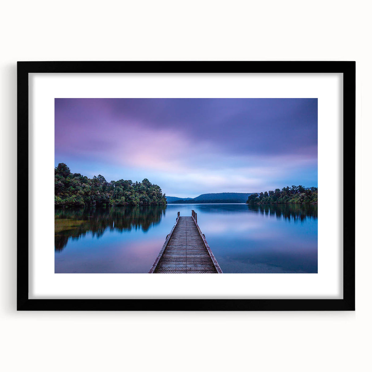 Colorful abstract art print of New Zealand's West Coast in a black frame, featuring vibrant, textured hues.