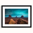 Colorful abstract art print of Monument Valley in vibrant hues on a large textured canvas, framed in black.
