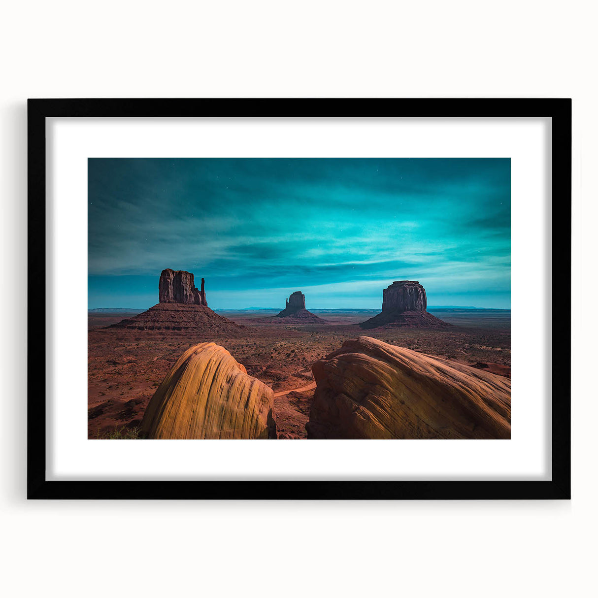 Colorful abstract art print of Monument Valley in vibrant hues on a large textured canvas, framed in black.