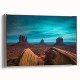 Framed canvas of Monument Valley landscape art painting in vintage poster style, featuring vibrant red and orange tones.