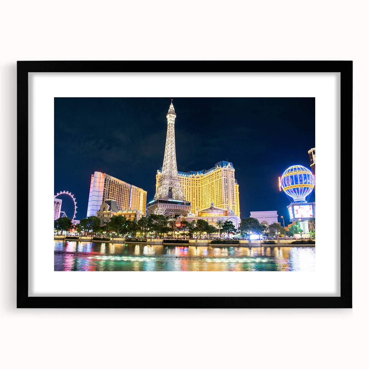 Colorful abstract art print of Las Vegas scenery in vibrant hues on textured canvas, framed in black.