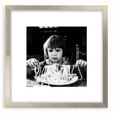 Textured abstract art print featuring people and food motifs in muted colors, framed in silver, ideal for bedroom wall decor.