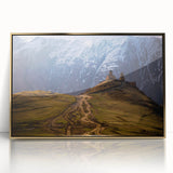Large art print of a serene Georgian landscape in muted earth tones on a gold-framed acrylic.