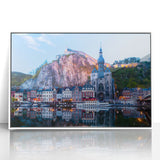 Mid-century modernist art depicting a serene European landscape in muted green and blue tones, acrylic print framed in white.