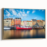 Framed canvas featuring a vintage-style landscape painting of a European scene, predominantly in black and gold tones.