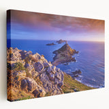 Large art depicting the scenic coastline of Corsica in muted blue and green tones on a stretched canvas.