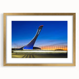 Abstract art print depicting a European cityscape in muted gray and blue tones, framed in gold.