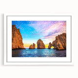 Art deco poster of Cabo San Lucas scenery in muted blue and tan hues, framed with a white mat.