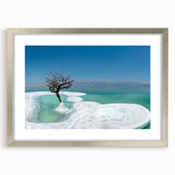 Textured art print depicting the Dead Sea in muted blue and gray tones, framed in silver, ideal for bedroom art.