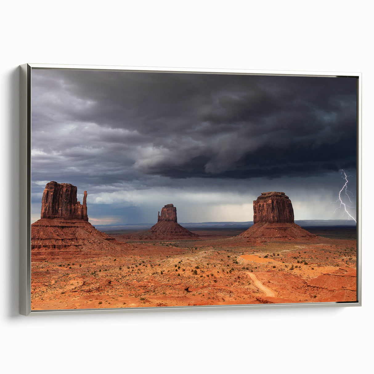Framed canvas depicting Monument Valley in Arizona with vivid blue sky and red rock formations, suitable for office decor.