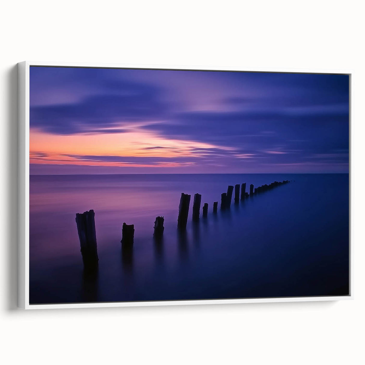 Framed canvas artwork depicting a serene beach landscape with gentle waves and soft pastel colors, showcased from a white side view for a modern touch.