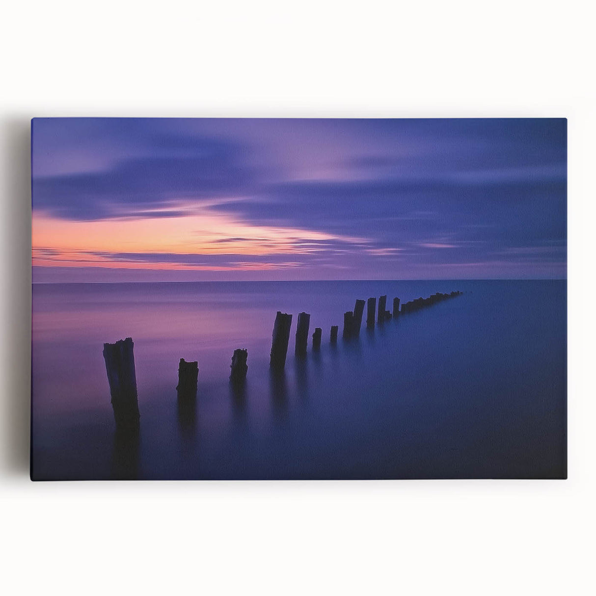 Stretched canvas artwork depicting a serene beach landscape at sunset, featuring vibrant colors of orange and blue, perfect for home decor or coastal-themed spaces.