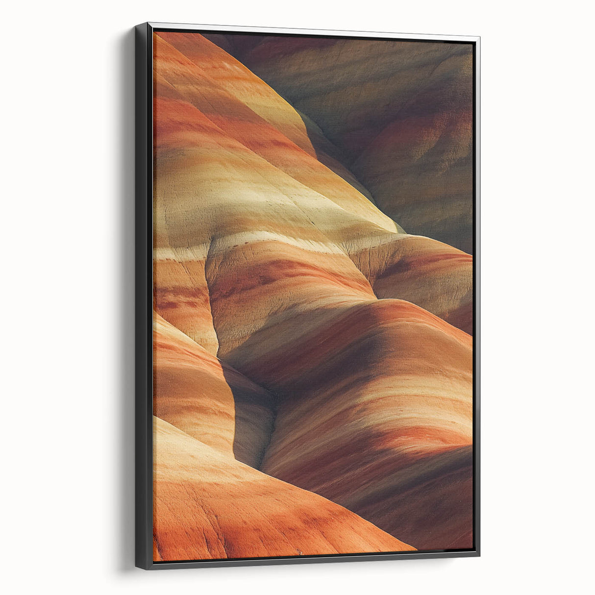 Framed canvas artwork depicting a vibrant desert landscape with warm earth tones, showcased in a sleek black frame, ideal for home decor and art enthusiasts.