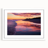 Framed landscape artwork depicting tranquil beaches with a white mat, showcasing soft blues and sandy tones, perfect for enhancing coastal-themed decor.