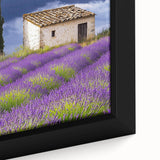 Close-up of a framed canvas print depicting a serene countryside landscape, featuring lush green fields and a vibrant blue sky, ideal for home decor.