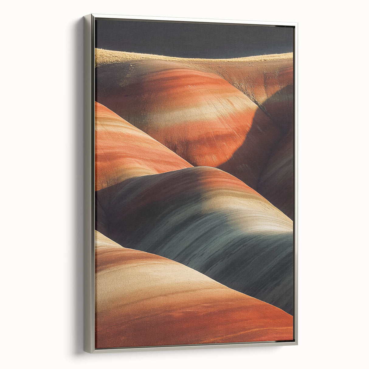 Framed canvas print of a vibrant desert landscape showcasing warm sandy tones and striking blue skies, elegantly displayed with a silver frame, ideal for home decor.