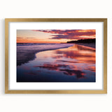 Elegant gold-framed landscape artwork showcasing a serene beach scene with soft waves and a vibrant sunset, perfect for coastal home decor.