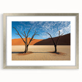 Desert landscape artwork framed in a sleek silver frame with a mat, showcasing warm tones of beige and orange, perfect for enhancing modern home decor.