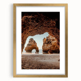 Framed landscape artwork featuring a cave scene, elegantly displayed with a gold mat. The design highlights earthy tones and intricate details, perfect for enhancing home decor.