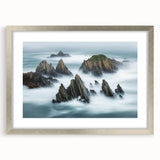 Elegant silver-framed landscape artwork showcasing dramatic cliffs under a clear blue sky, designed with a white mat for added depth. Perfect for modern home decor.
