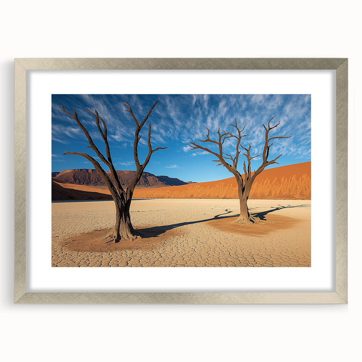 Desert landscape artwork framed in silver with a white mat, showcasing warm tones of sand and sky, ideal for modern home decor. Perfect for nature enthusiasts.